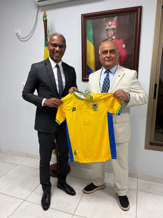 Deux hommes tenant un maillot, d’après la légende le ministre des Sports du Gabon et Numan Hatipoglu.